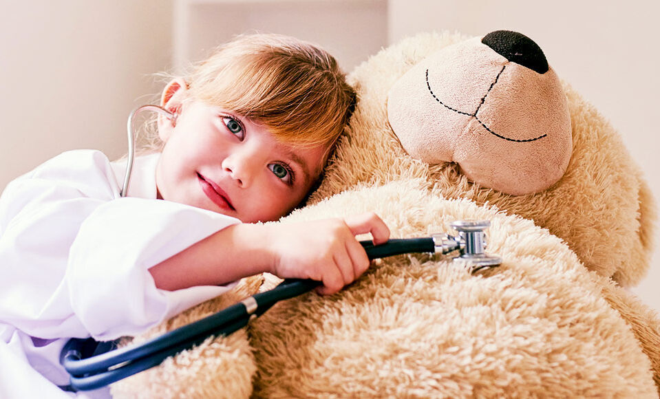 jeune fillette jouant au medecin avec son teddy bear