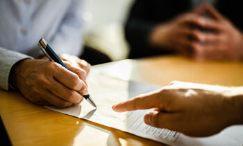 gros plan sur un homme signant un contrat lors d'une réunion