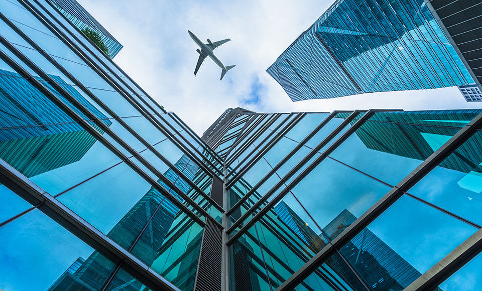 avion dans un ciel au milieu des immeubles - D&eacute;velopper l&rsquo;International
