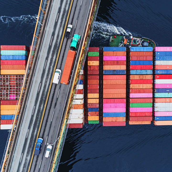 cargo avec conteneurs color&eacute;s sous un pont