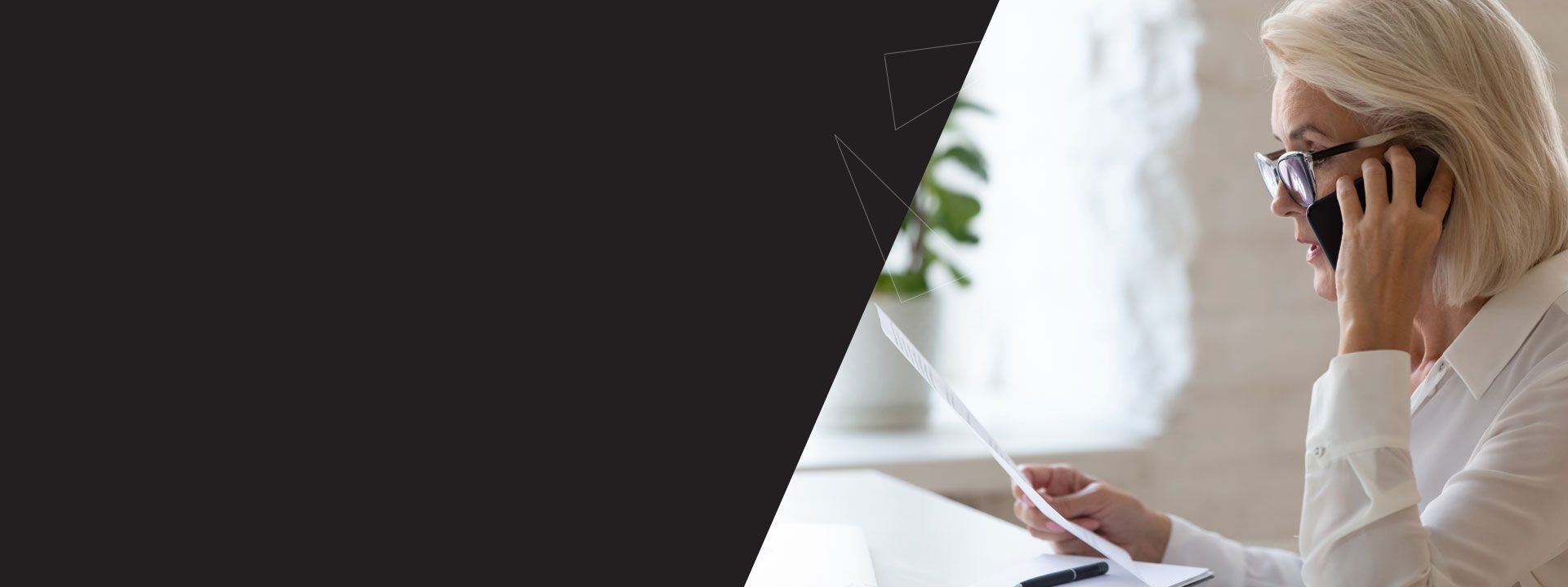 femme avec des lunettes en communication t&eacute;l&eacute;phonique qui lit un document papier