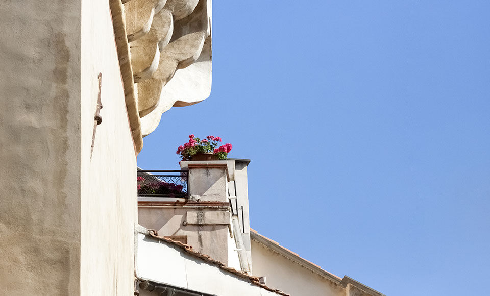 toiture et haut d'immeuble abim&eacute; avec balconni&egrave;res fleuries