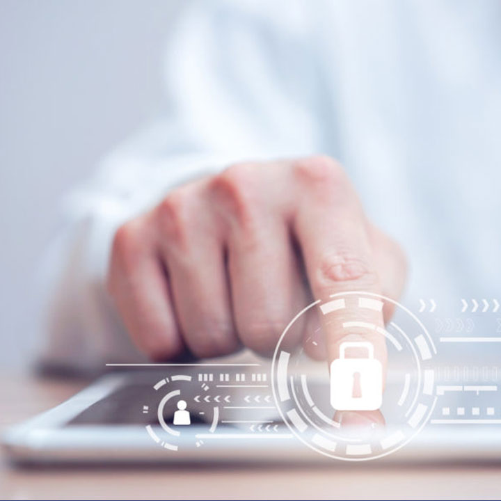 homme qui touche une tablette pos&eacute;e sur un bureau avec cadenas digital en r&eacute;alit&eacute; augment&eacute;e