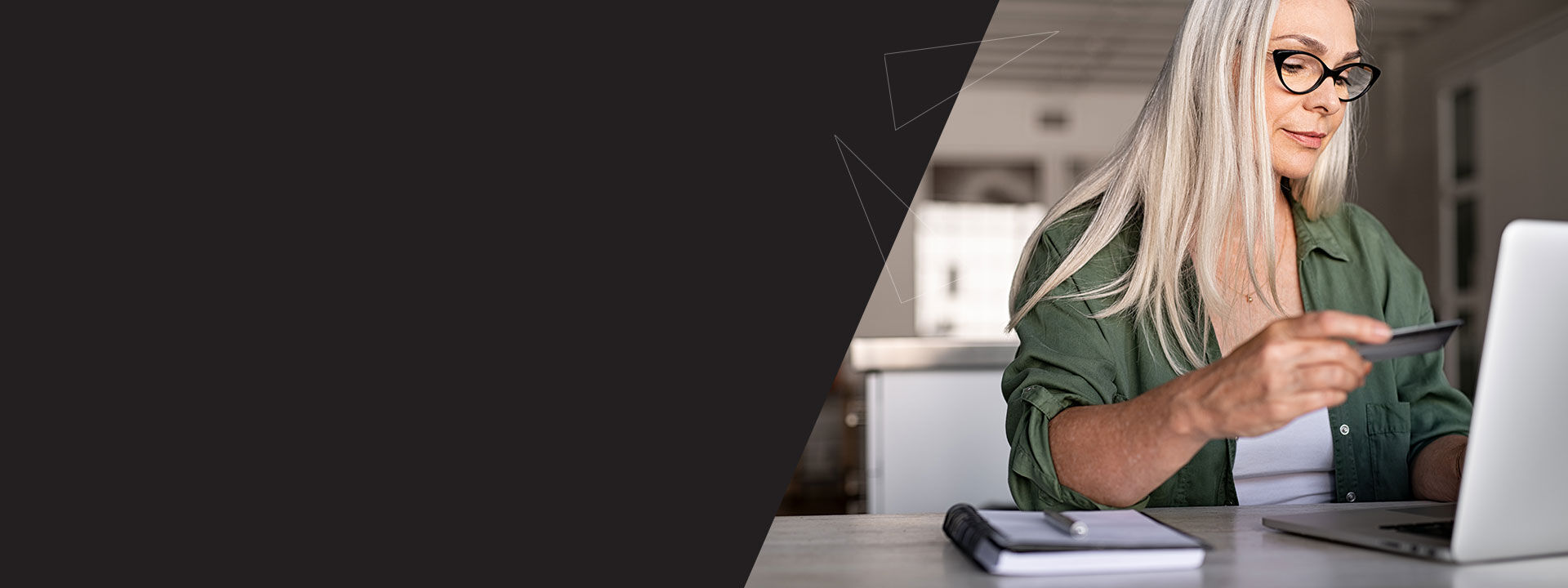 femme assise à son bureau devant son ordinateur effectuant un paiement en ligne avec sa carte