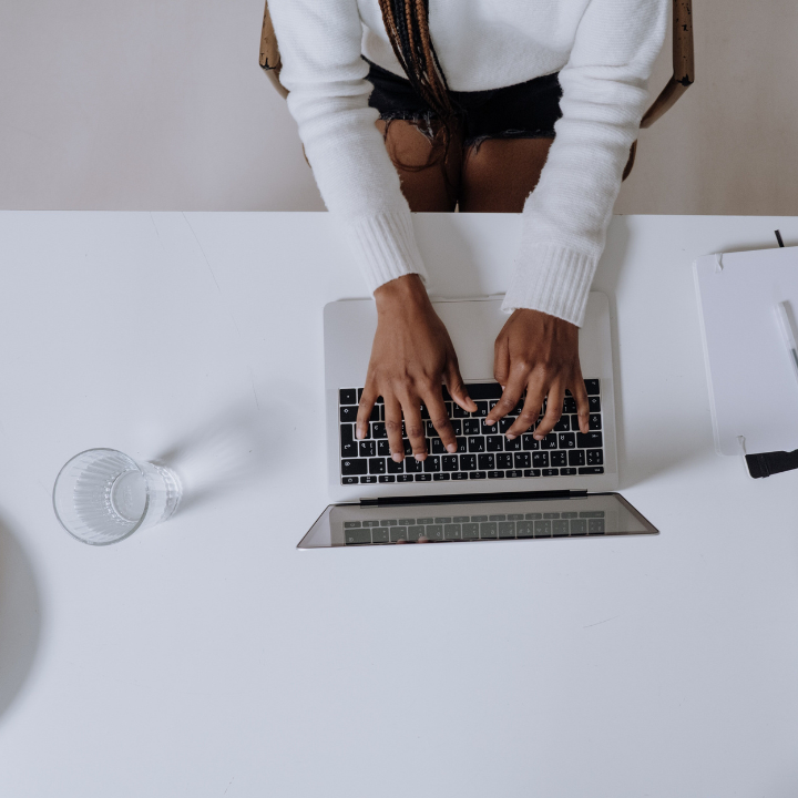 Une personne saisit des informations sur un ordinateur portable pos&eacute; sur un bureau.