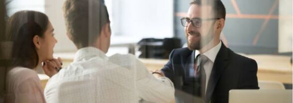 Conseiller qui est face à face avec un couple de client dans une agence Bancaire Banque Palatine