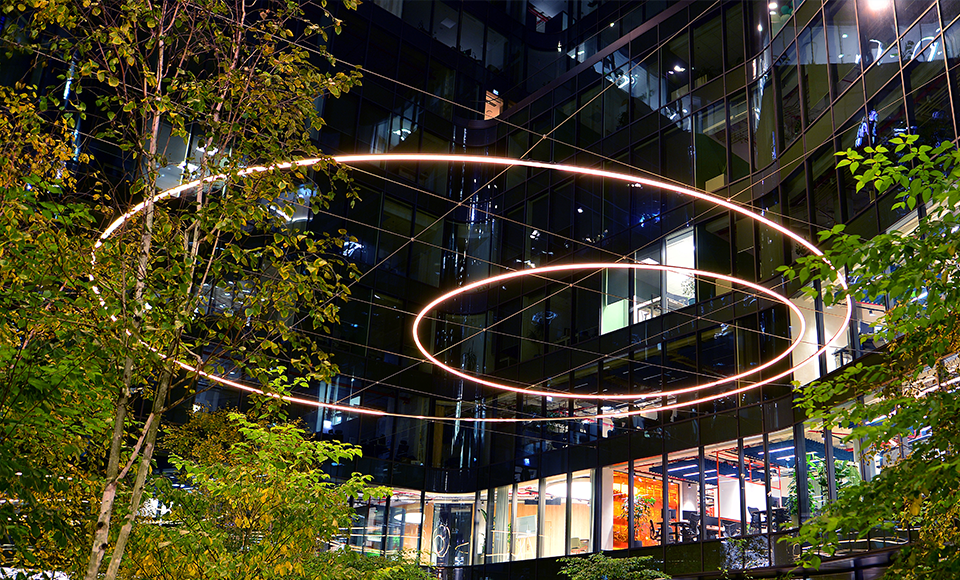 immeuble illumin&eacute; avec des arbres - Accompagner la transition environnementale de votre entreprise