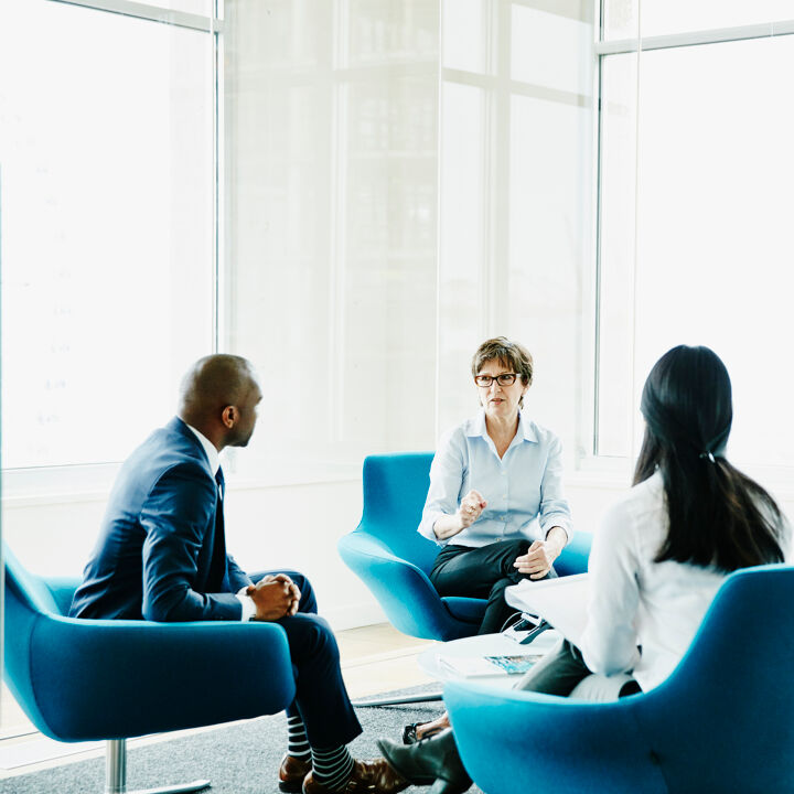 Mature-businesswoman-leading-meeting-in-office