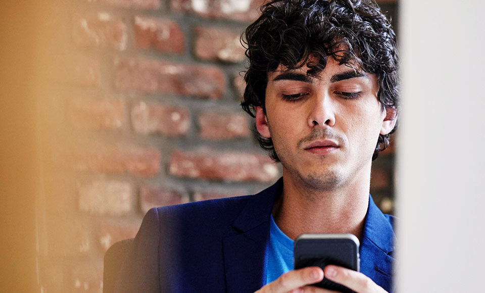 homme veste smartphone mur