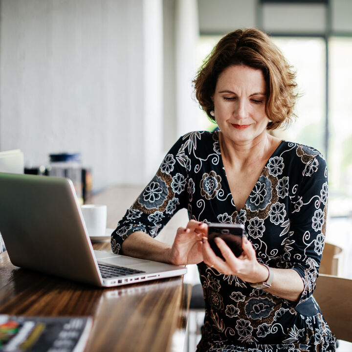 Femme d'affaires travail à l'aide de smartphone alors qu'il était assis au bar du restaurant