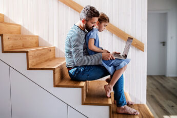 Homme regardant un ordinateur avec son enfant