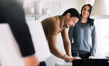 Jeune couple signant l'achat de son bien immobilier