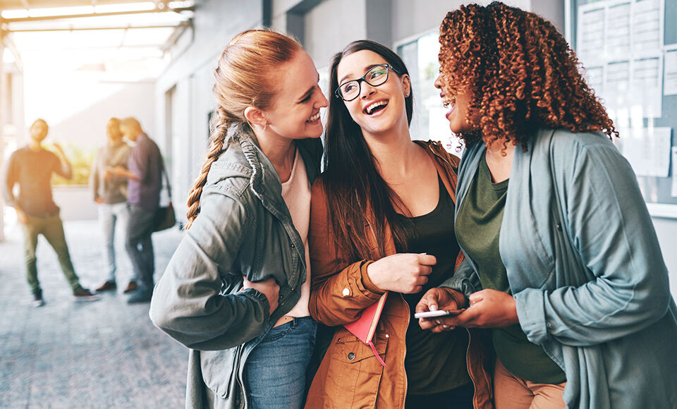 trois etudiantes souriante et discutant dans les couloirs