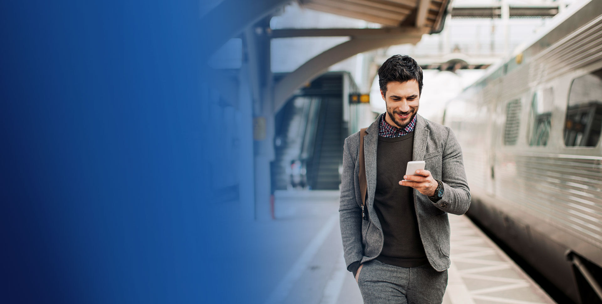 banniere jeune homme souriant regardant un telephone dans une gare