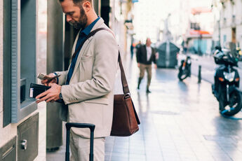 jeune homme Retire de l’argent au distributeur sans carte bancaire
