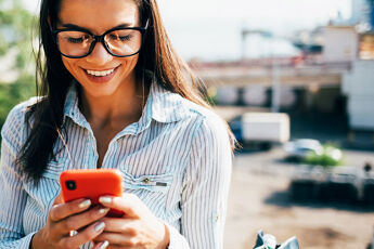 jeune fille a lunettes regardant le telephone rouge