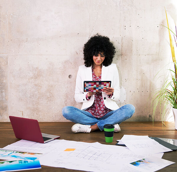 jeune femme cheveux bouclé regardant une tablette