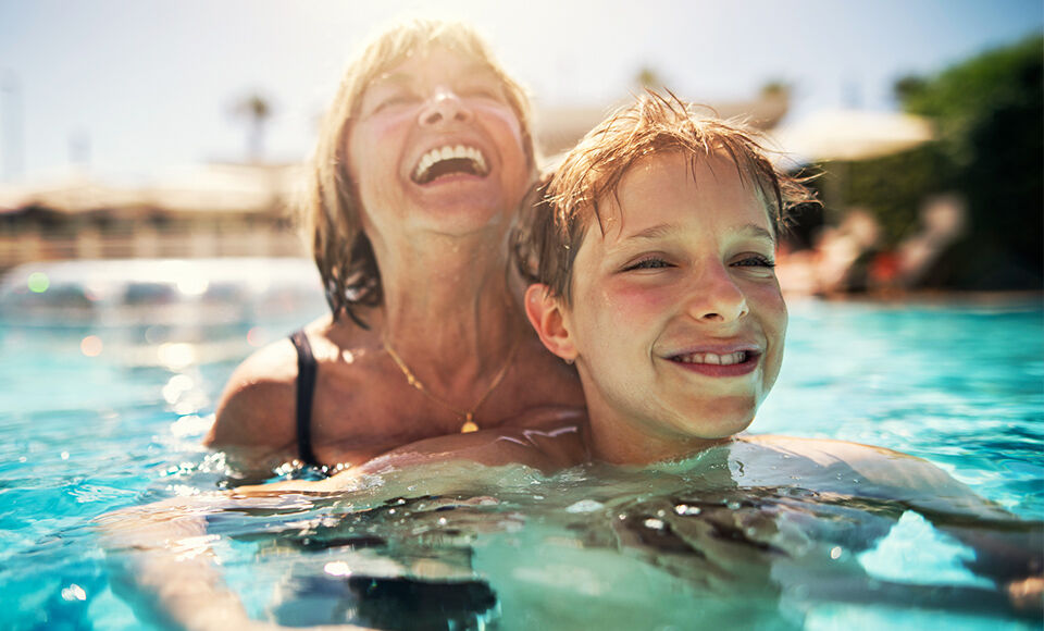 grand-mere se baignant avec son petit fils dans la piscine