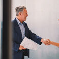 Femme mure serrant la main d'un homme mure apres signature de contrat