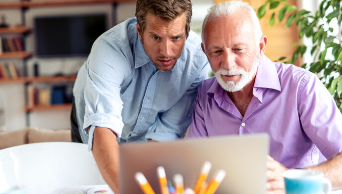 Image de deux hommes d'affaires discutant d'un nouveau projet dans un bureau moderne.