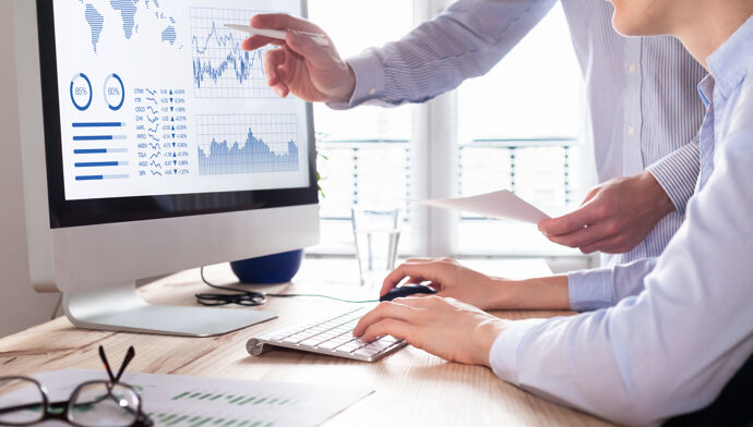 Deux personnes analysant la stratégie d'investissement en bourse sur ordinateur