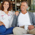 homme et femme mures souriant assis canapé