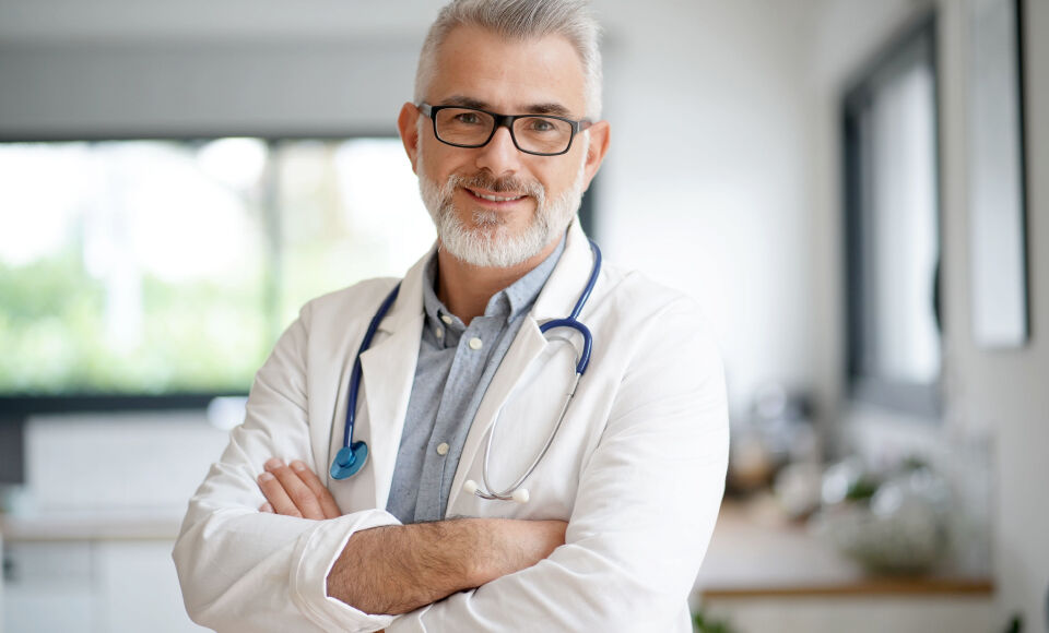 homme mure médecin souriant