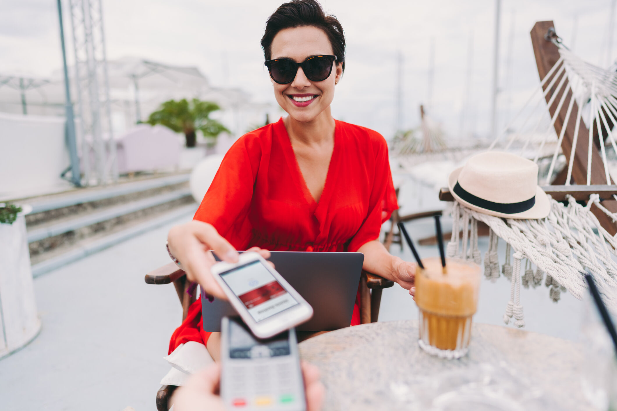Femme au caf&eacute; de la plage payant sans contact avec smartphone