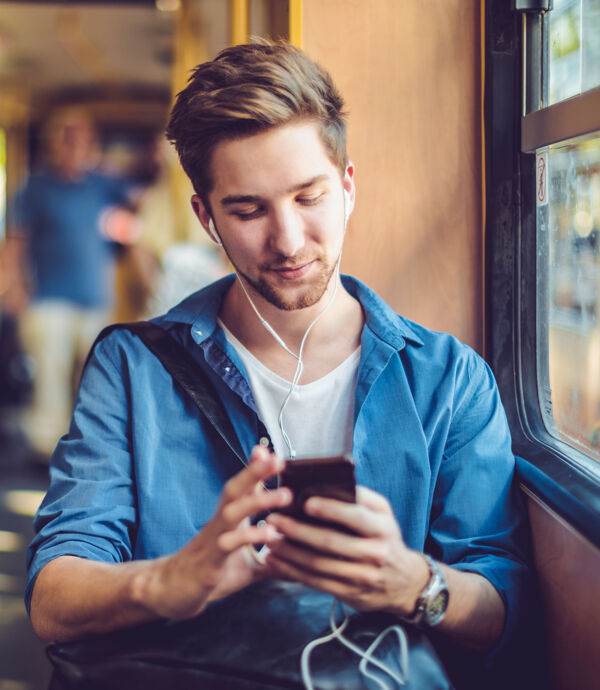 Jeune homme vérifiant les messages sur son téléphone intelligent