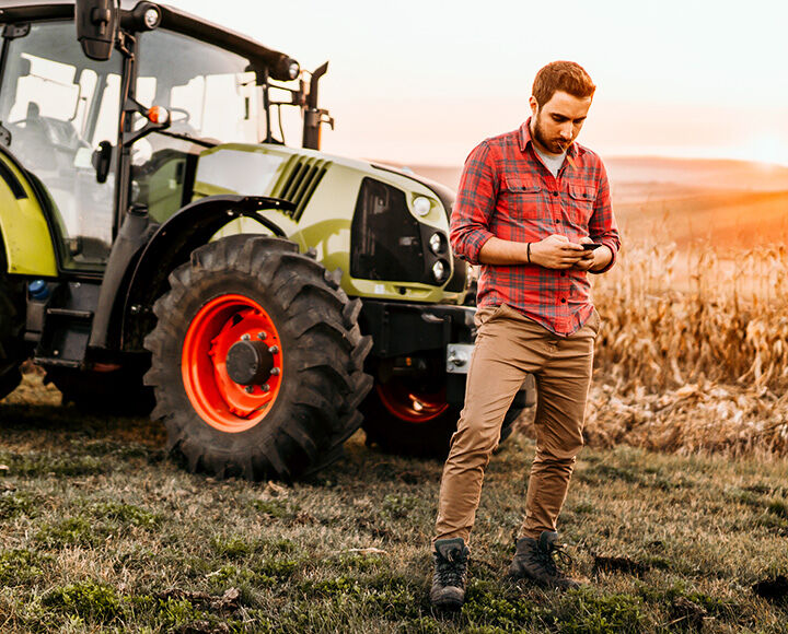 homme avec une tablette devant un tracteur