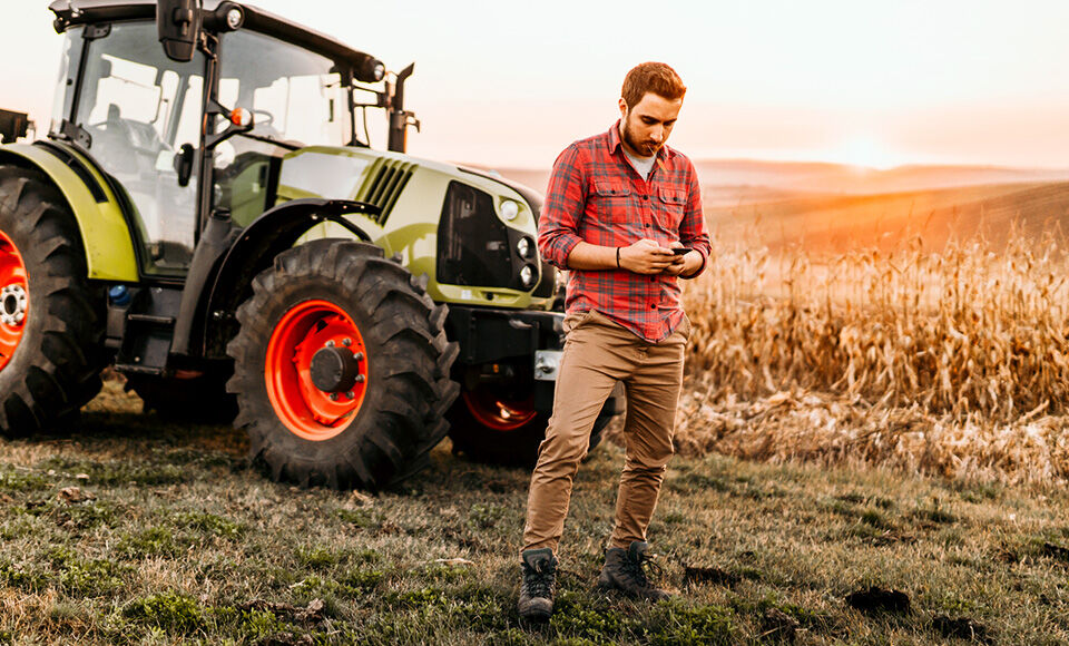 homme avec une tablette devant un tracteur