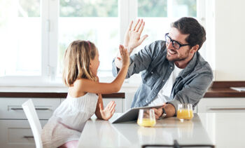 Un homme tape dans la main d'une petite fille.